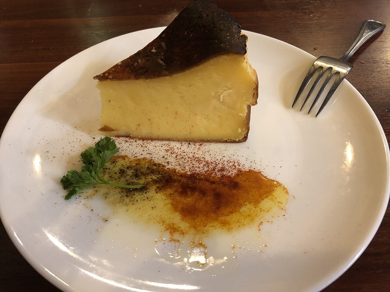 Porción de tarta de queso vasca hecha con queso crema, de interior liso y cremoso