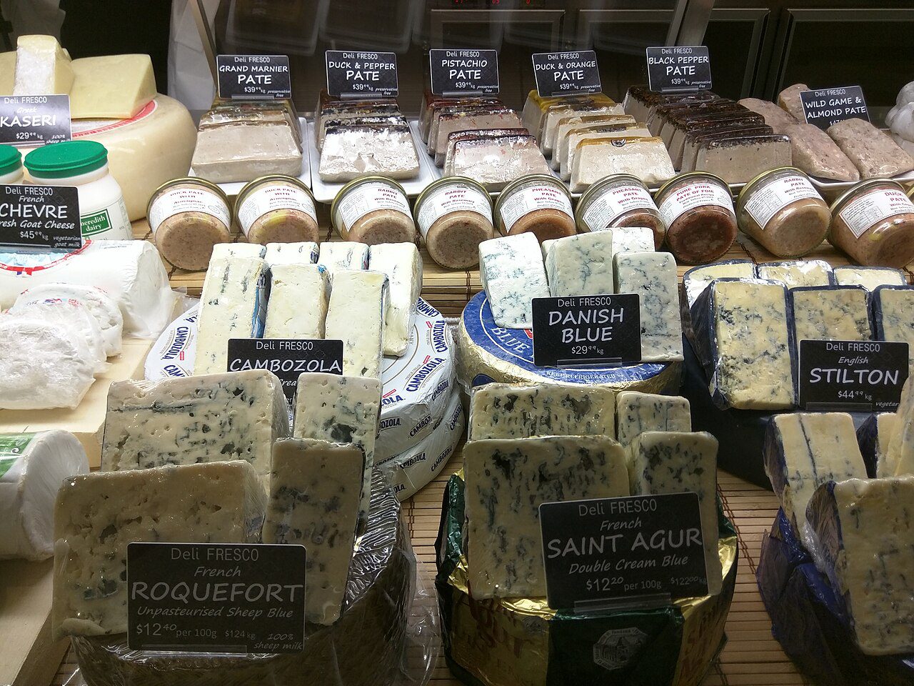 Distintos quesos azules sobre una tabla, usados en pequeñas cantidades para la tarta de queso